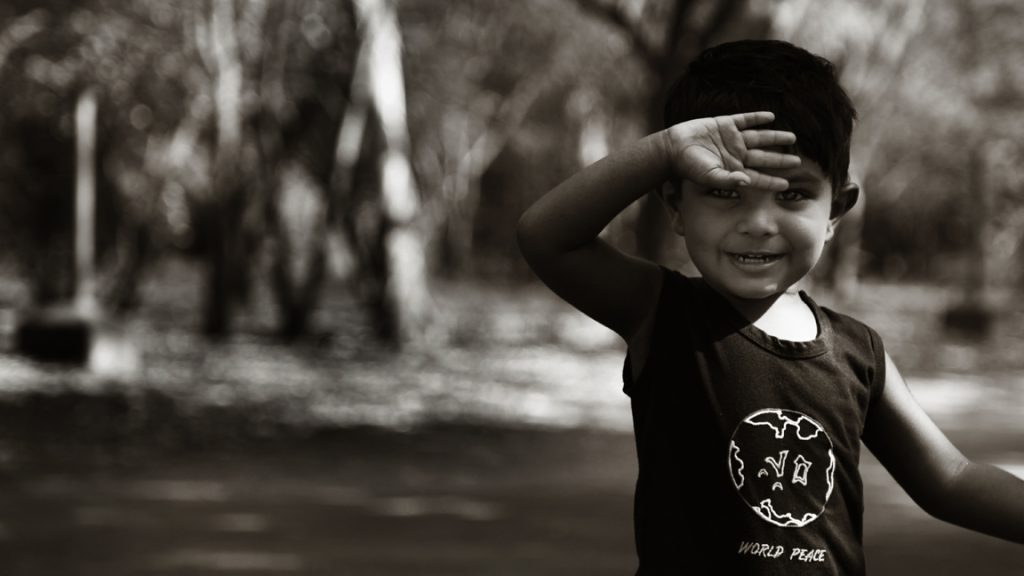 Photo sépia d’un enfant avec une main devant les yeux